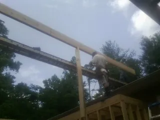 Carpenter setting a ridge beam over a new addition frame — Ice Dam Removal by Roofing Brothers in Astor