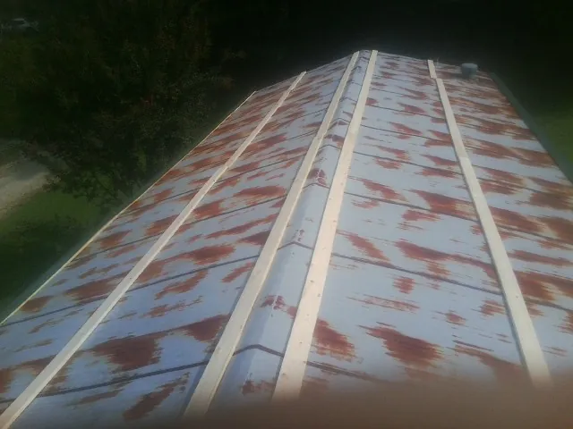 Rusted metal roof panels with new wood purlins before replacement — Storm Damage Roof Repair in Astor by Roofing Brothers