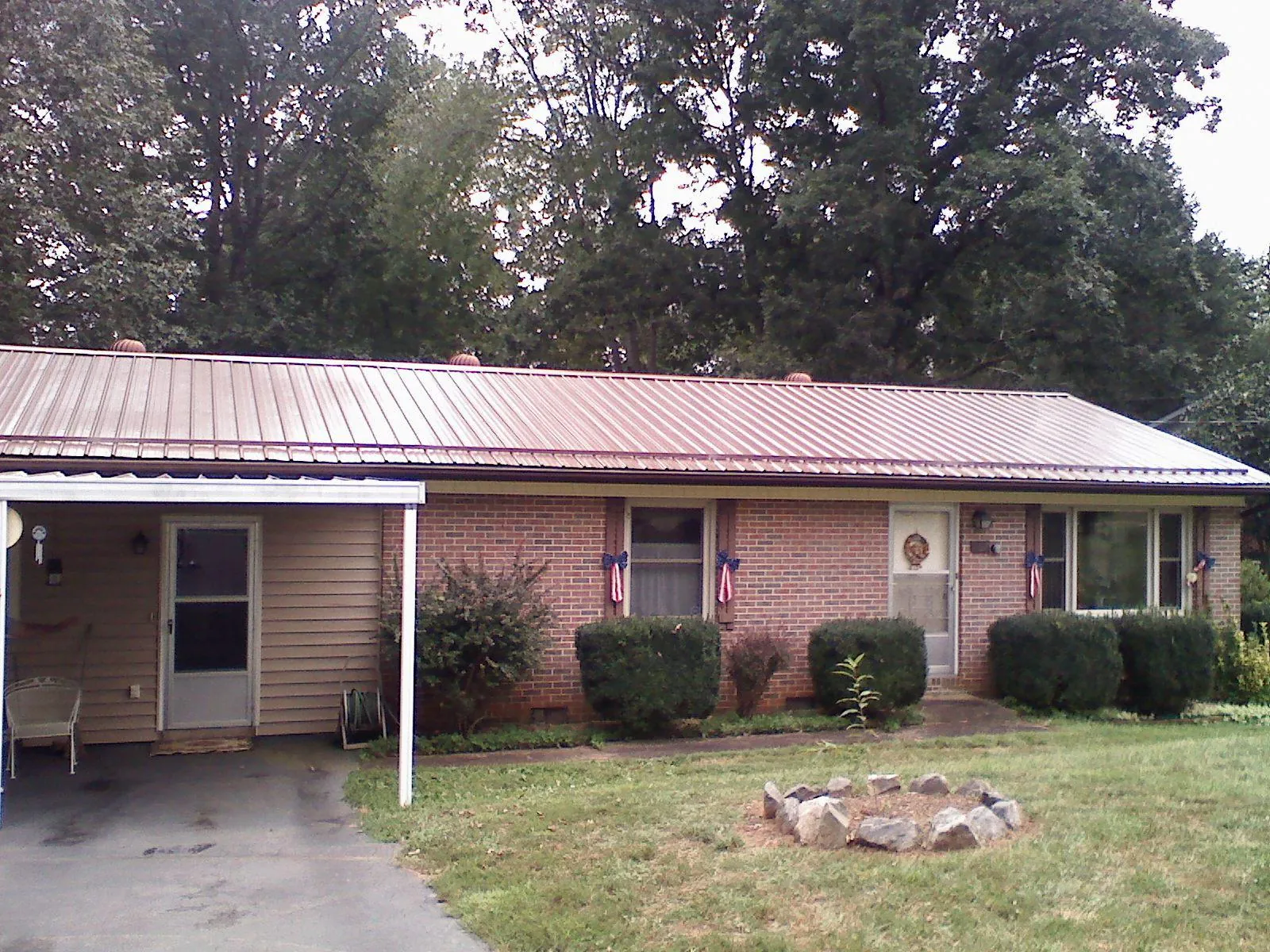 Bronze metal roof and carport on a brick ranch home — Roof Repair work by our crew in Astor